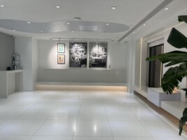 Un vestíbulo amplio y moderno, con techo alto, iluminación empotrada y un banco a lo largo de la pared.