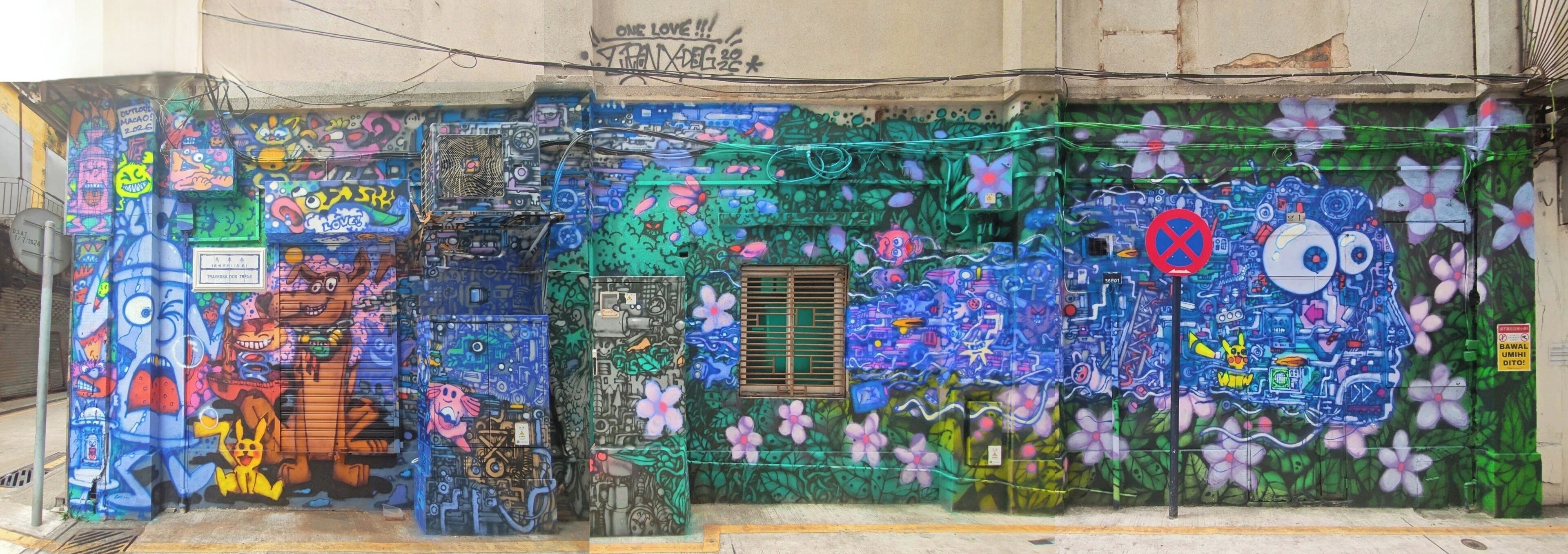Facciata di un edificio interamente ricoperta da graffiti colorati, con diversi personaggi dei cartoni animati e motivi astratti.