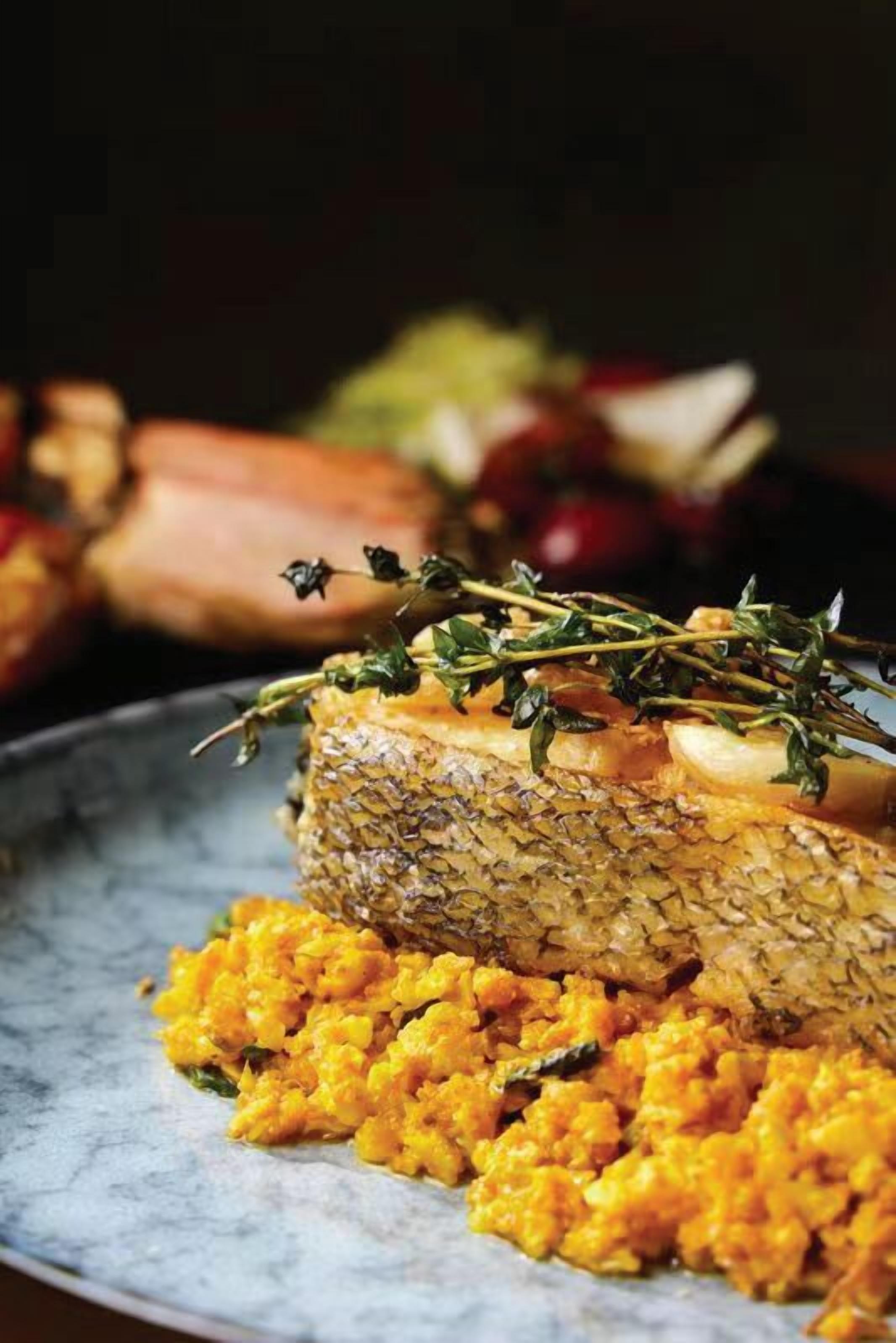 A dish with fish and a garnish of herbs.