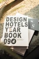 Una pila de folletos con el título "DESIGN HOTELS YEAR BOOK 090".