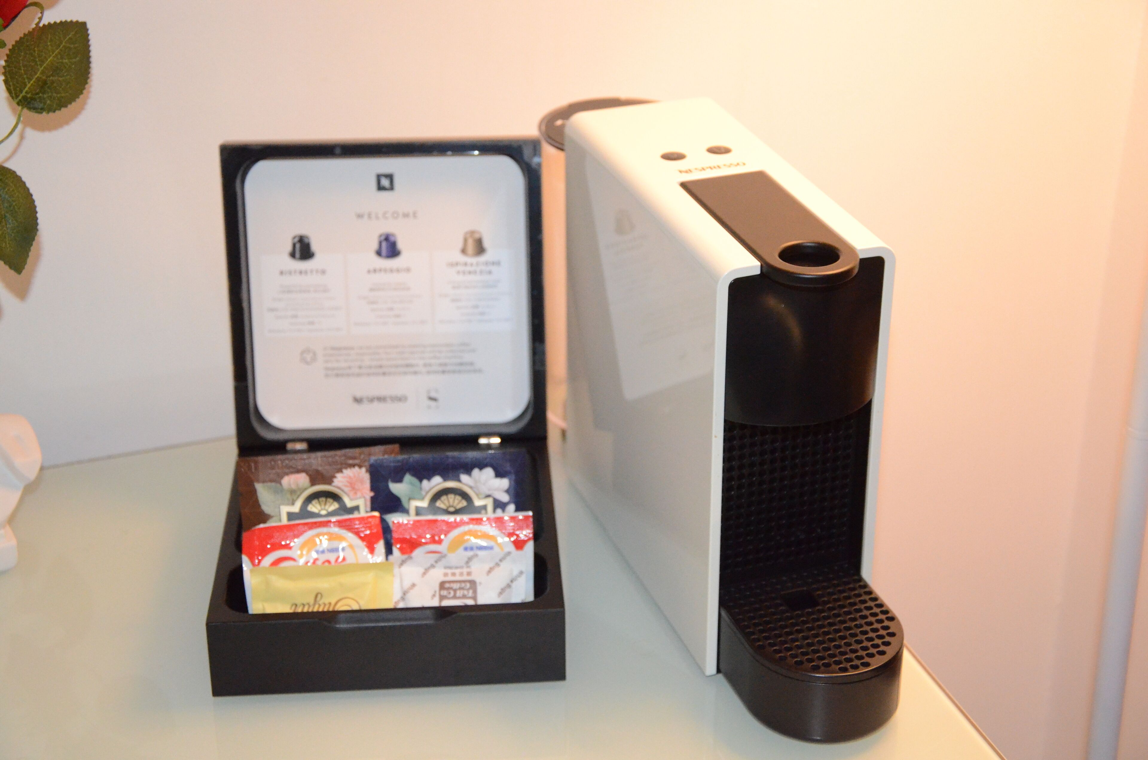 A coffee machine with a display panel and a coffee pod holder.