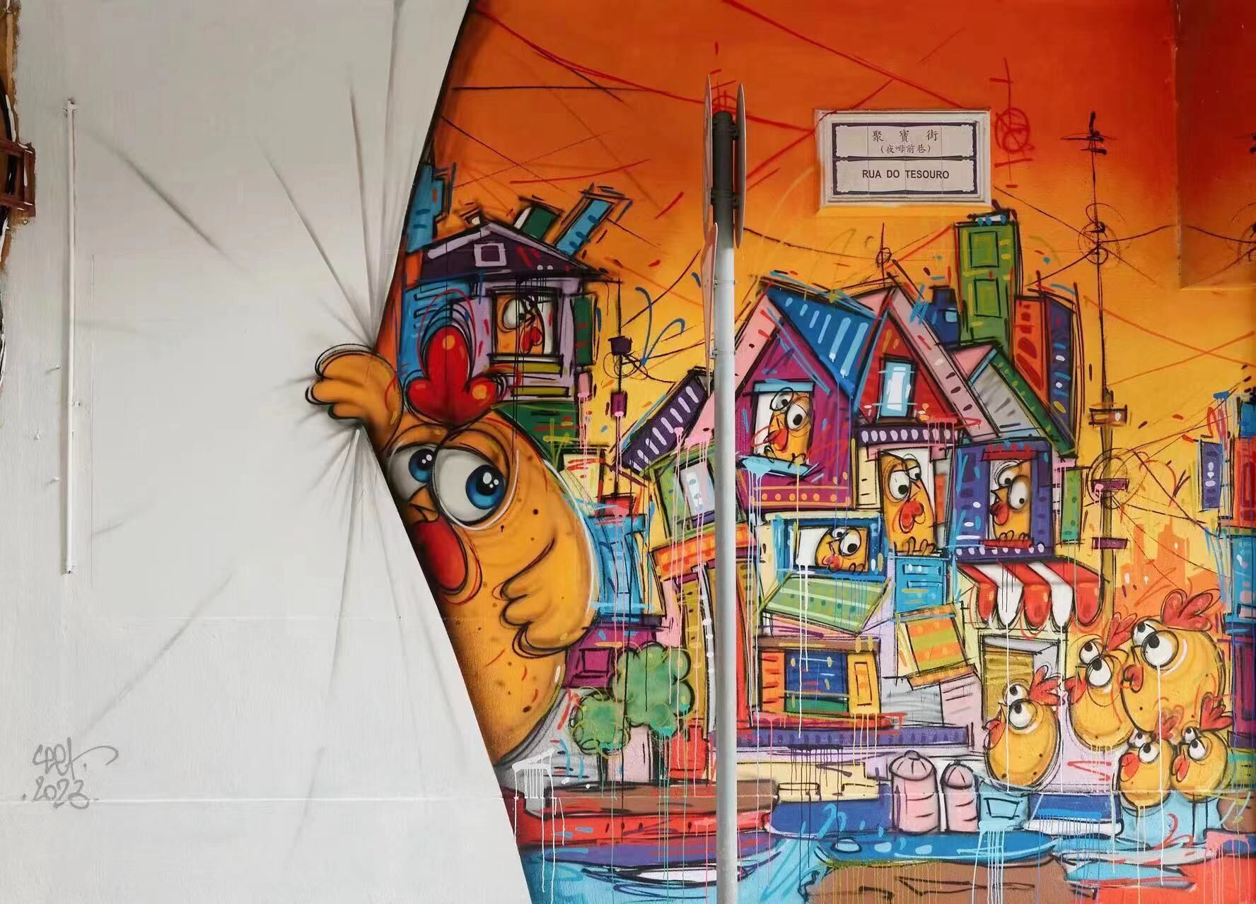 Un mural colorit amb pollets de dibuix animat i cases.