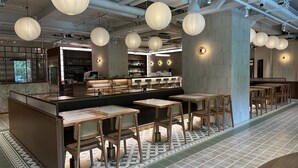 A modern restaurant interior with exposed ceilings, hanging paper lanterns, a bar area, and patterned floor tiles. - Macau Hotel S (Macau)