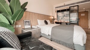 A modern bedroom with a bed, bedside table, and a large plant. - Macau Hotel S (Macau)