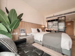 Relax in a serene space with a large bed, black headboard, and city view.