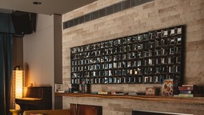 A cozy seating area with wooden pallets as chairs, a wall-mounted bookshelf, and a warm ambient light source. - Superbude Altona Paradise (Hamburg)