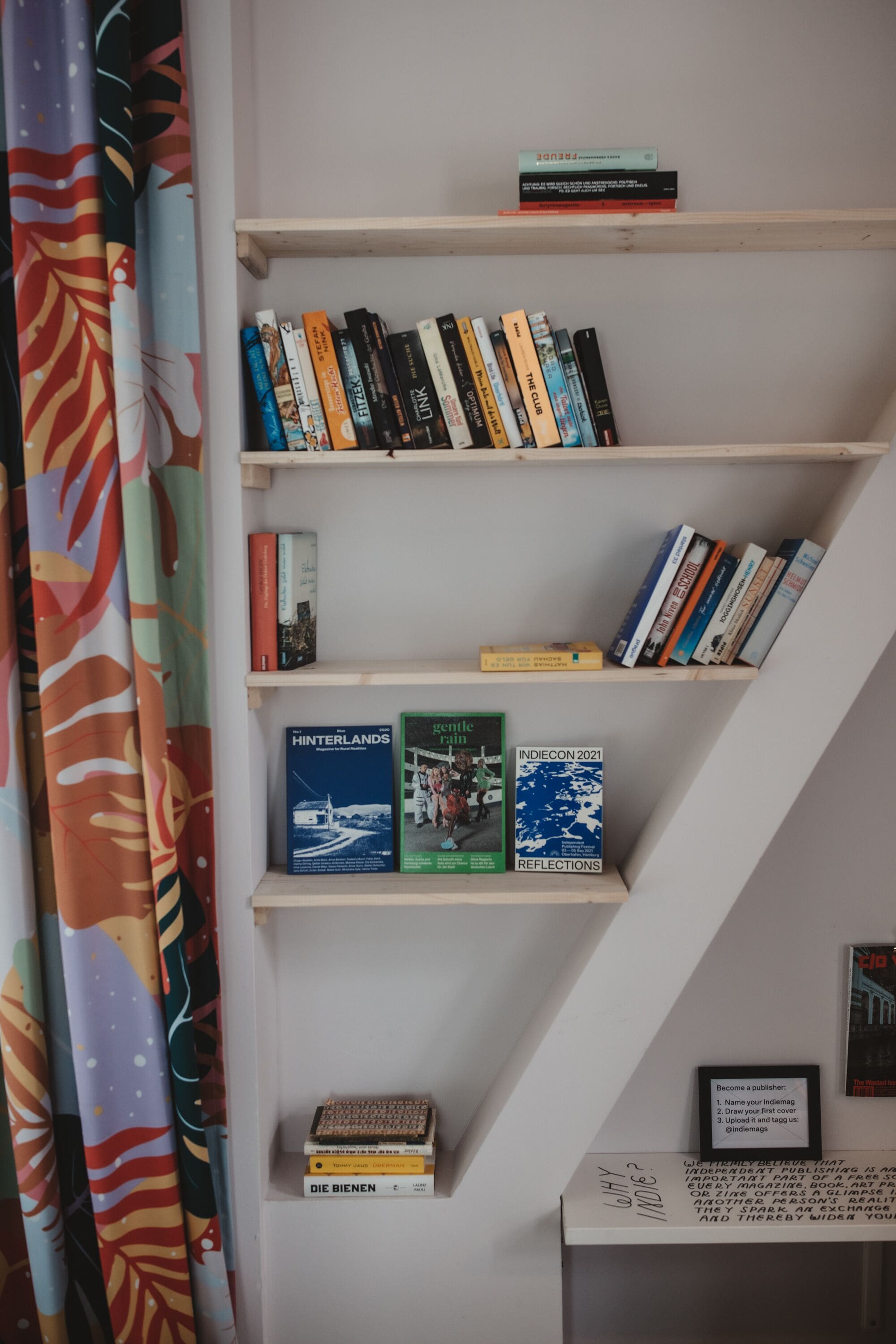 Ein Bücherregal mit verschiedenen Büchern und einer gerahmten Gebrauchsanweisung.