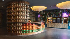 A reception area with a circular wooden counter displaying a variety of footwear. - Superbude Altona Paradise (Hamburg)