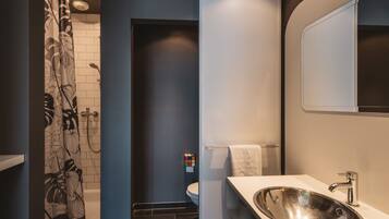 A modern bathroom with a shower curtain, a sink, and a mirror.