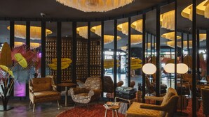 A modern interior with leather armchairs, a red carpet, and a large mirror reflecting the room. - Superbude Altona Paradise (Hamburg)