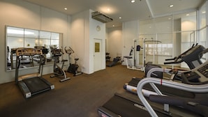 Un gimnasio moderno con cintas de correr, elípticas y equipo de pesas.