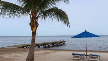 En la playa, playa de arena blanca, camastros y sombrillas
