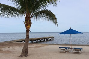 On the beach, white sand, sun-loungers, beach umbrellas