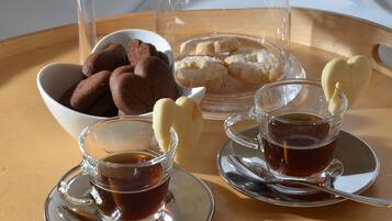 A tray with cookies, a glass of tea, and a glass of coffee.