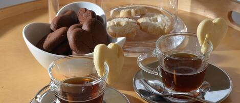A tray with cookies, a glass of tea, and a glass of coffee.