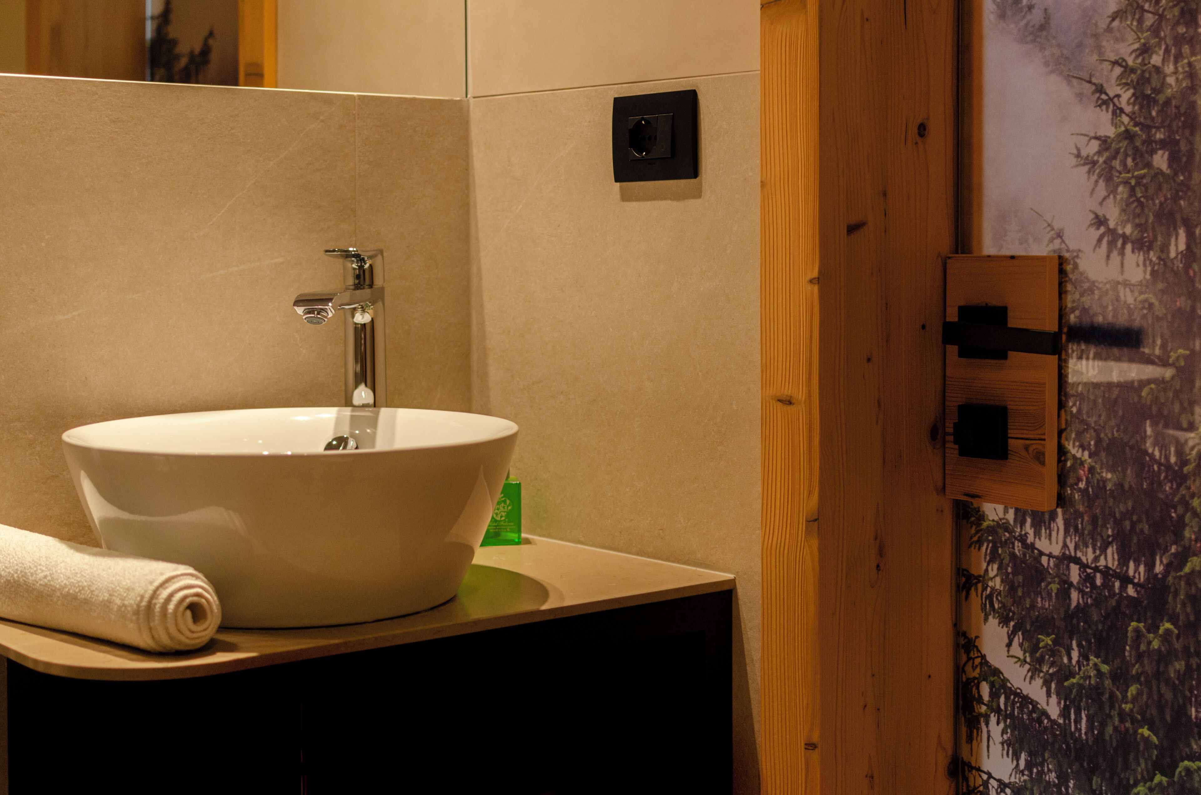 A bathroom with a large white sink, a mirror, and a wooden door.