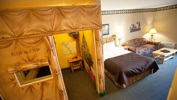 A room with a bed, a sofa, a small table, and a tent-like structure labeled "KID KAMP".