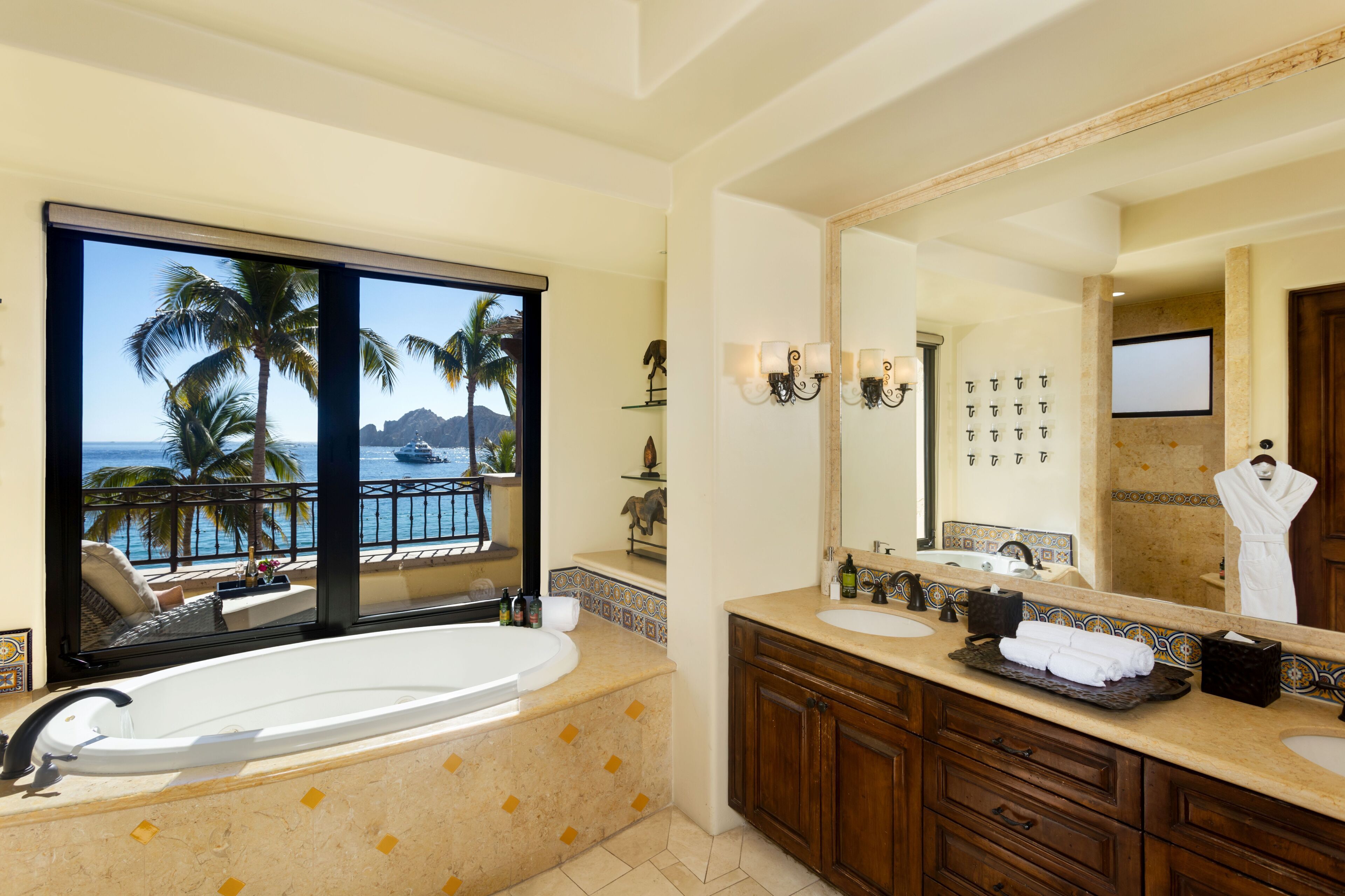 A luxurious bathroom with a large bathtub, dual sinks, and a large mirror.
