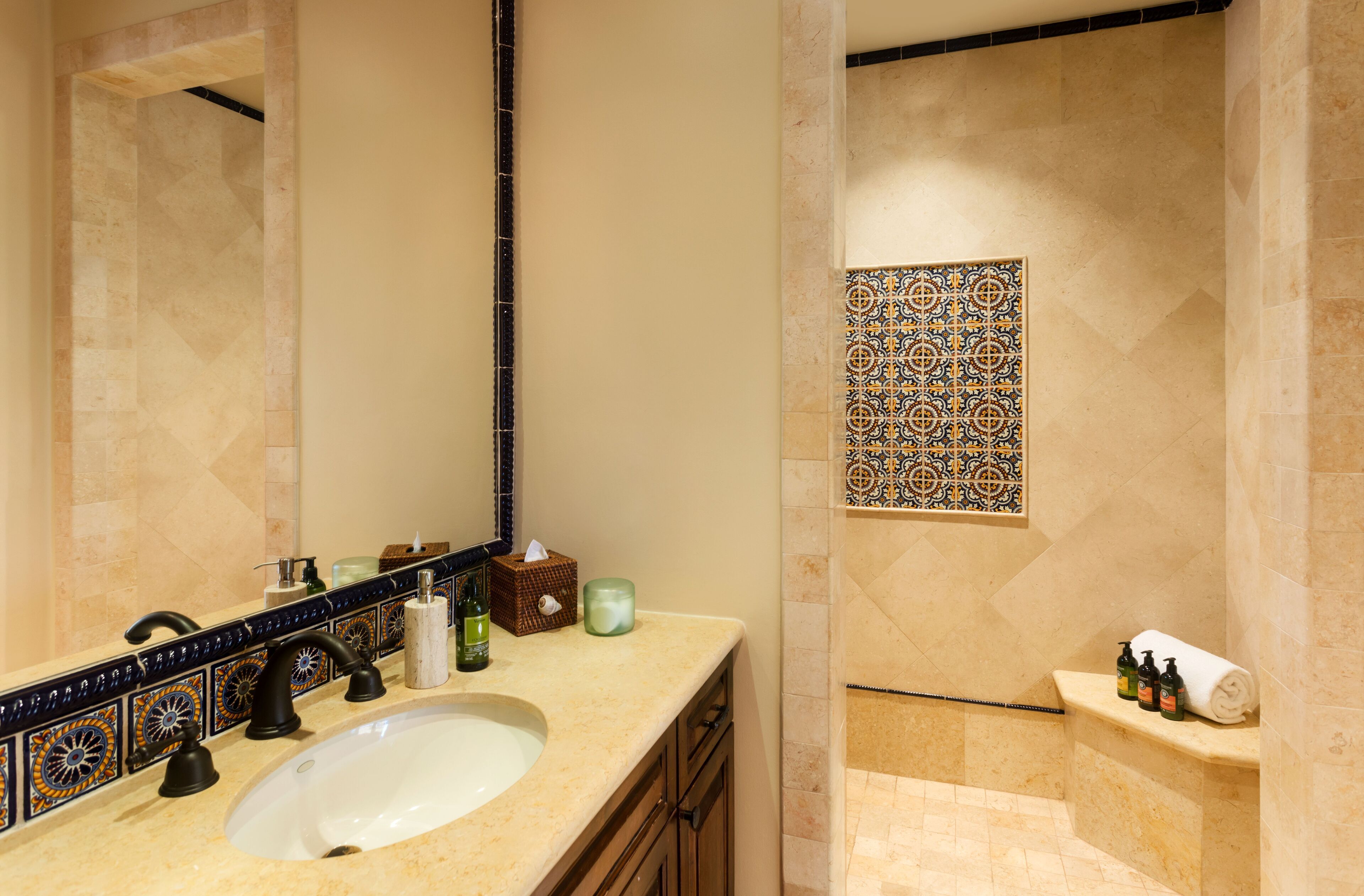 Une salle de bain avec un lavabo, un miroir et des murs carrelés.