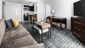 A modern living room with a sofa, a desk, and a television.