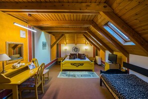 A bedroom with a wooden ceiling, a bed, a desk with a chair, a television, and a window. - Janus Boutique Hotel & Spa (Siófok)