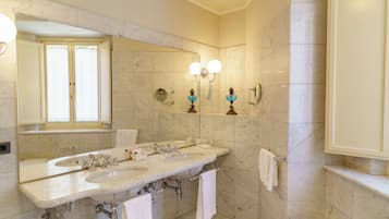 A bathroom with two sinks, a large mirror, and wall-mounted lighting.