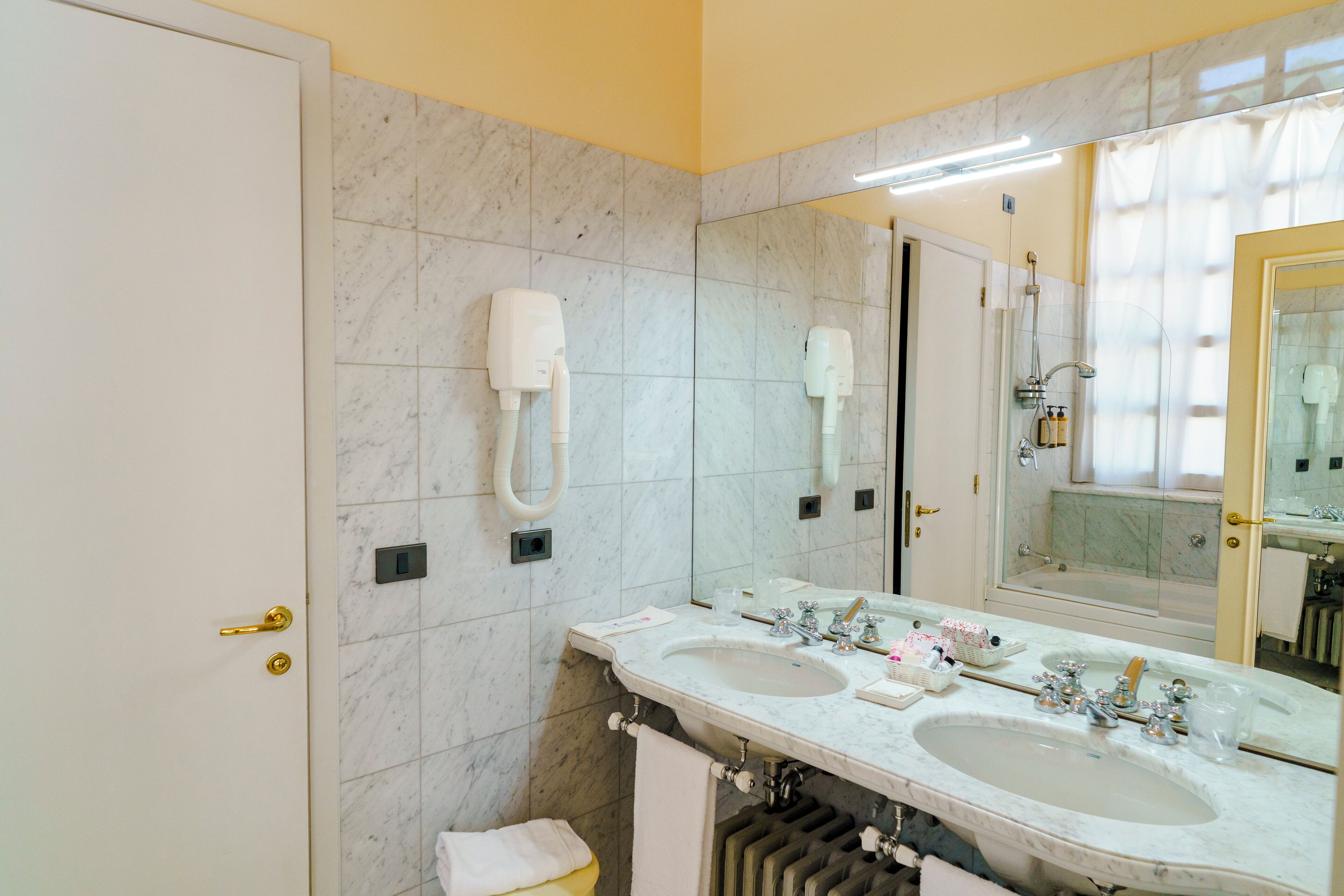 A bathroom with two sinks, a large mirror, and a towel rack.
