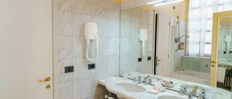 Un baño con dos lavamanos, un espejo grande y un perchero para toallas.