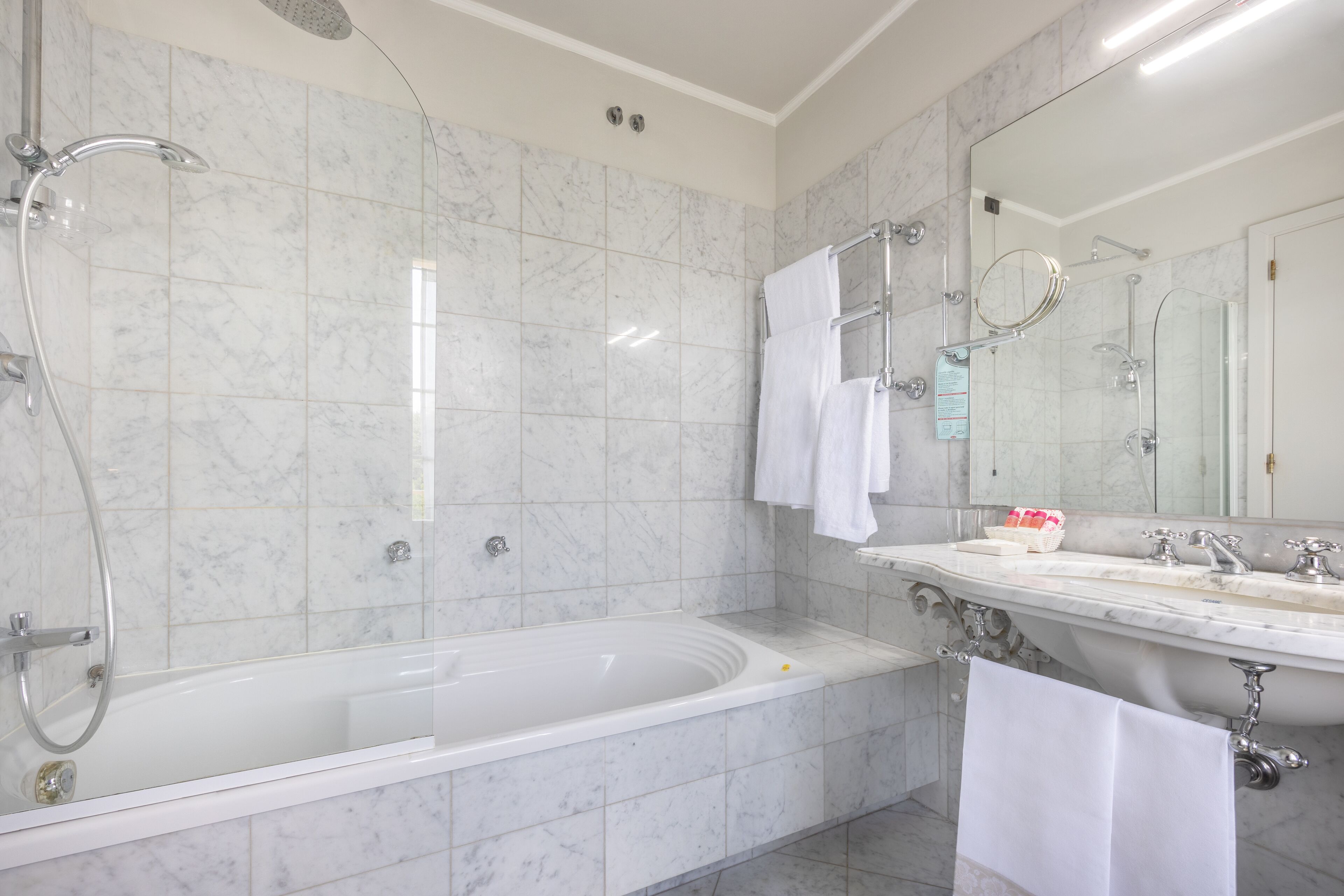 Ein modernes Badezimmer mit einer großzügigen Badewanne, einer separaten Duschkabine und einem Waschtisch mit Spiegel.