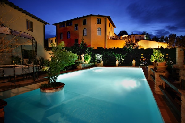 Una piscina al aire libre de temporada, sombrillas