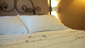 A neatly made bed with white linens and a decorative metal headboard. - Albergo Del Chianti (Greve in Chianti)
