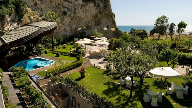 A resort with a pool, outdoor seating, and a view of the sea. - Hotel Serapo (Gaeta)