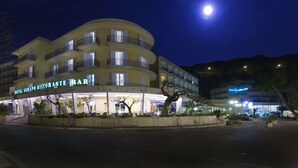 A hotel with a restaurant bar, multiple balconies, and a well-lit entrance. - Hotel Serapo (Gaeta)