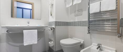 A modern bathroom with a sink, toilet, bidet, and bidet seat.