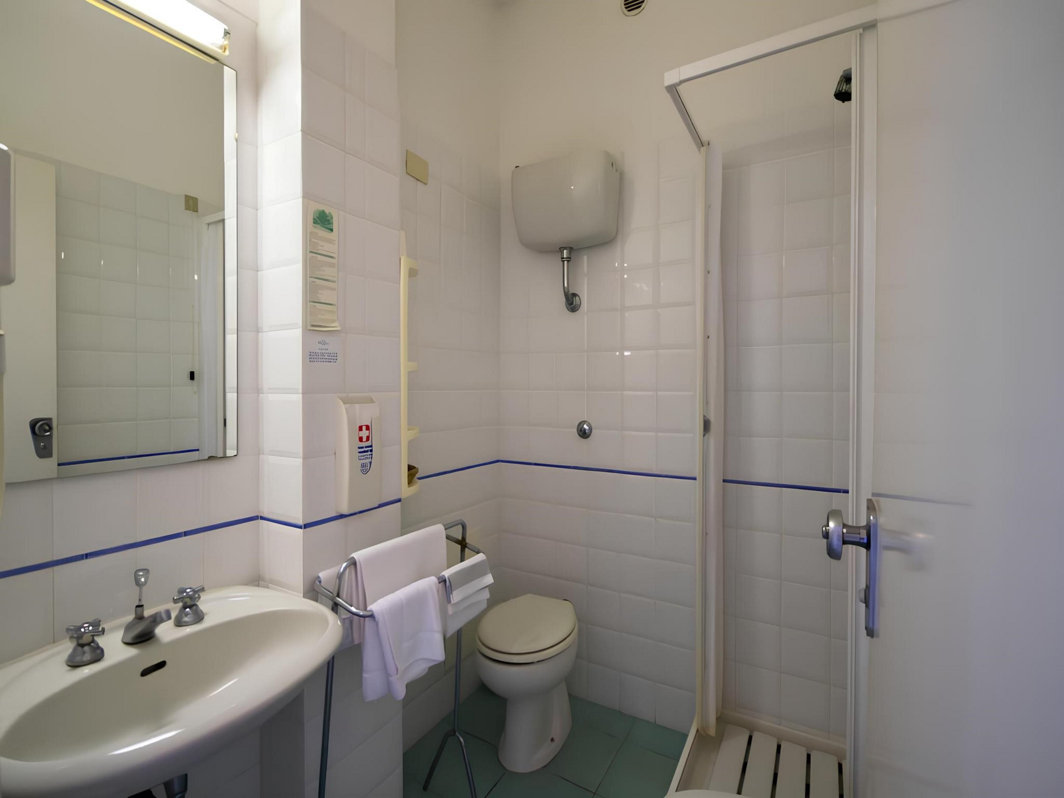 A bathroom with a sink, toilet, and shower.