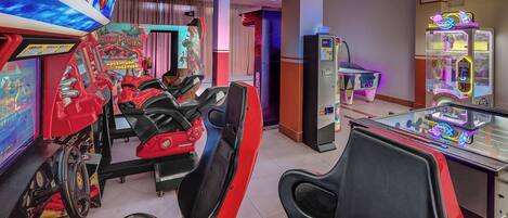 A gaming arcade with racing simulators and claw machines.
