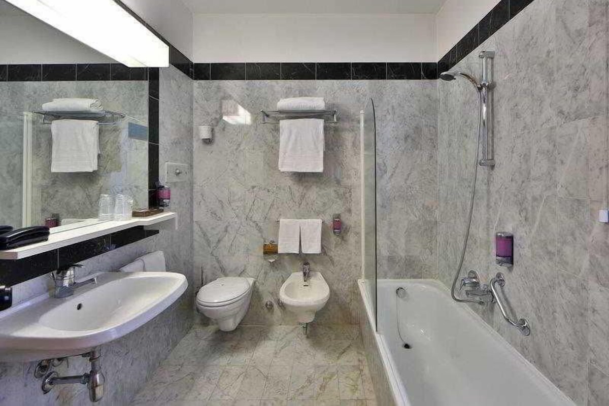 Un baño con lavamanos, inodoro, bidé y bañera.