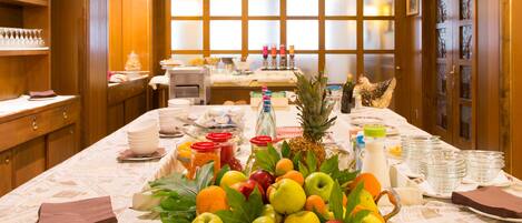 Una mesa de buffet con una variedad de frutas, bebidas y platos.