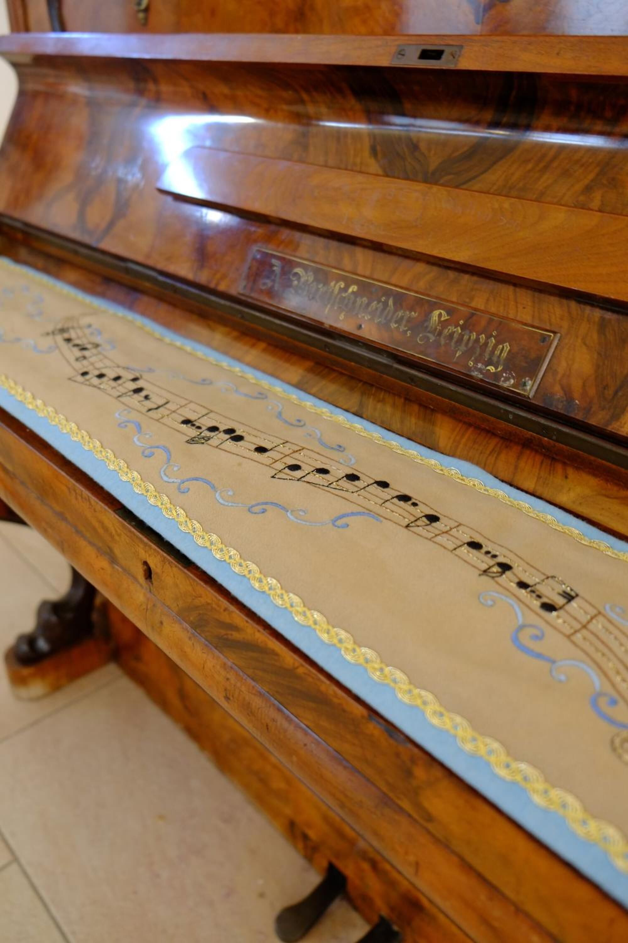 A wooden piano with sheet music on its surface.