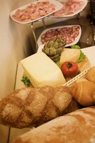 Un bufé con diversos alimentos, como sándwiches, queso y pan.