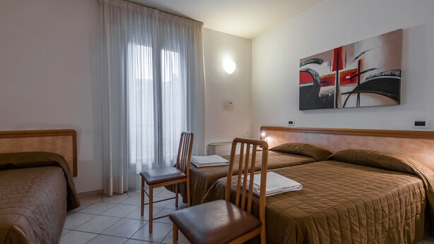 A hotel room with two beds, a chair, a table, and a painting on the wall. - Hotel Montebello (Montecatini Terme)