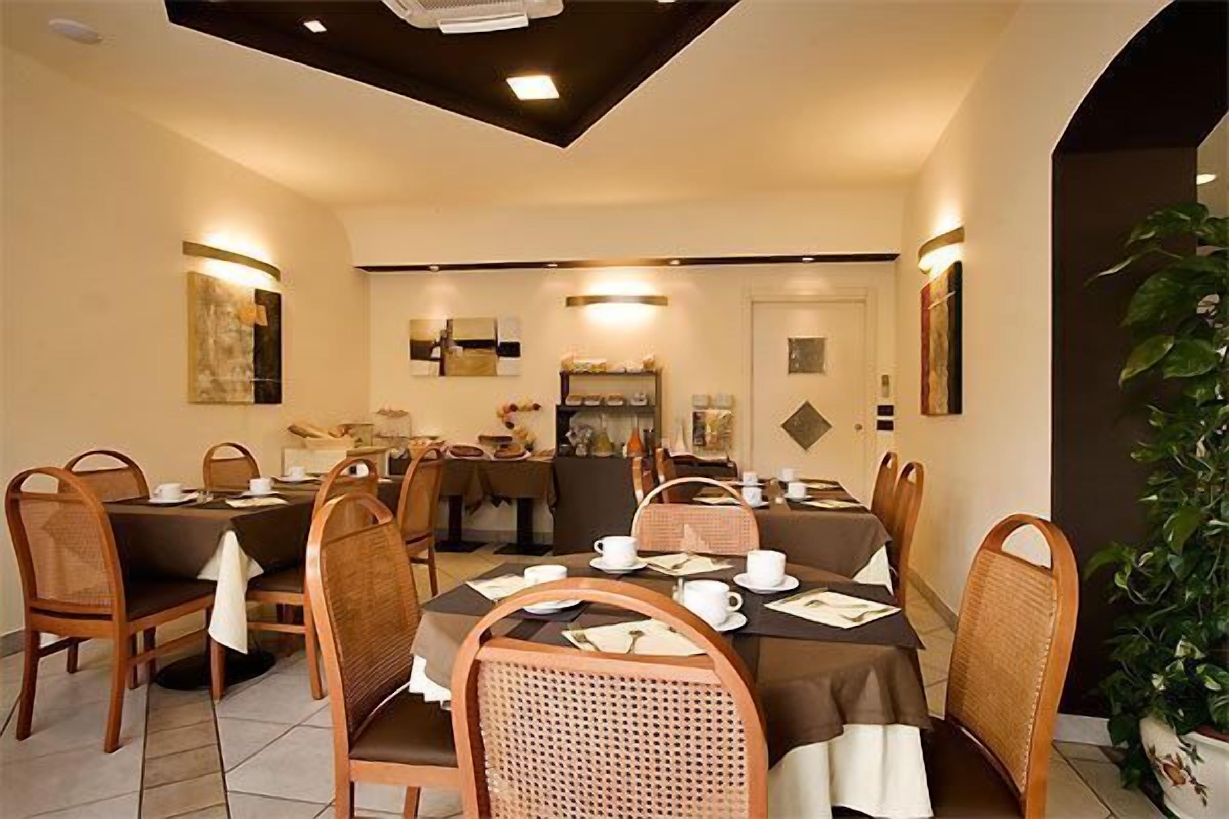 Een eetruimte met ronde tafels, stoelen en een centraal gelegen buffet.