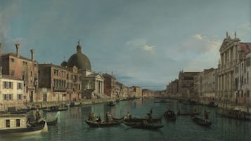 Escena de un canal con góndolas y edificios, incluyendo una cúpula destacada.