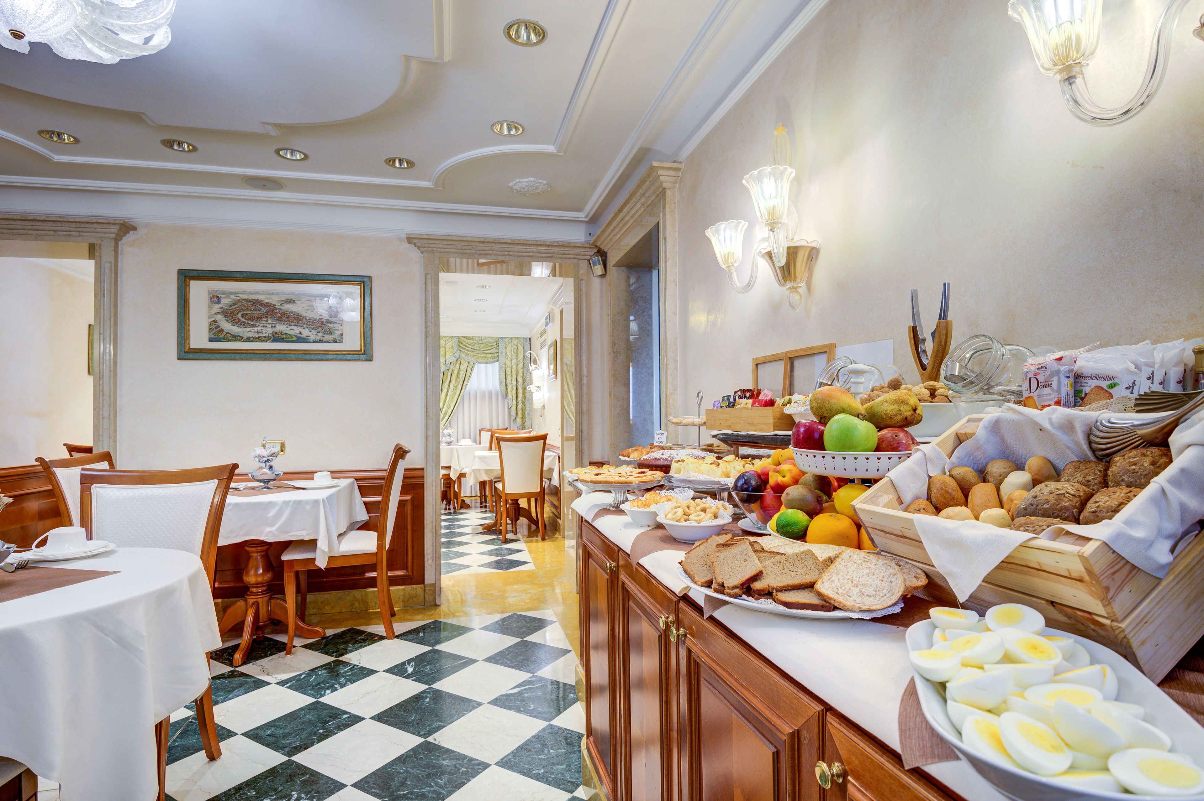 A hotel dining area with checkered flooring, wooden tables, and a buffet with various food items.