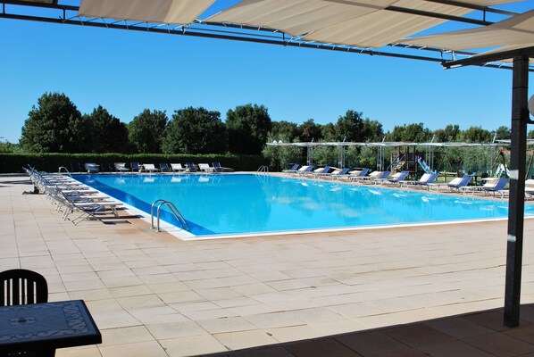 A swimming pool with lounge chairs and a children's play area. - Borgo degli Olivi (Piombino)