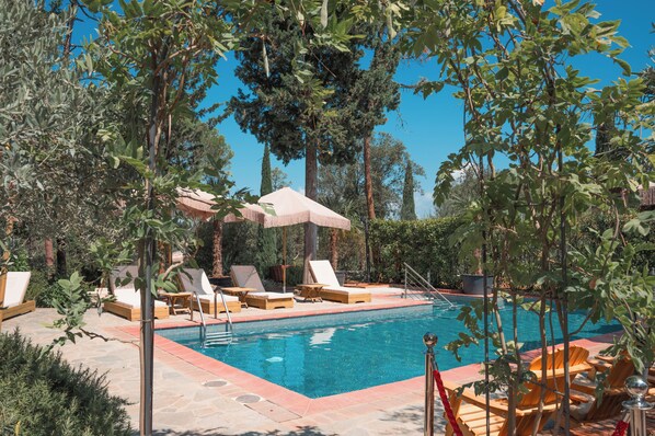 Piscine extérieure en saison, parasols, chaises longues