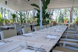 Dine al fresco amidst lush greenery and simple, clean architecture.