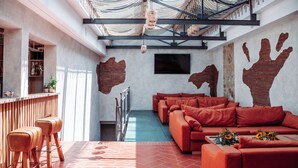 A modern interior with a bar area, seating, and a large handprint mural. - Hotel Villa Cesi (Impruneta)