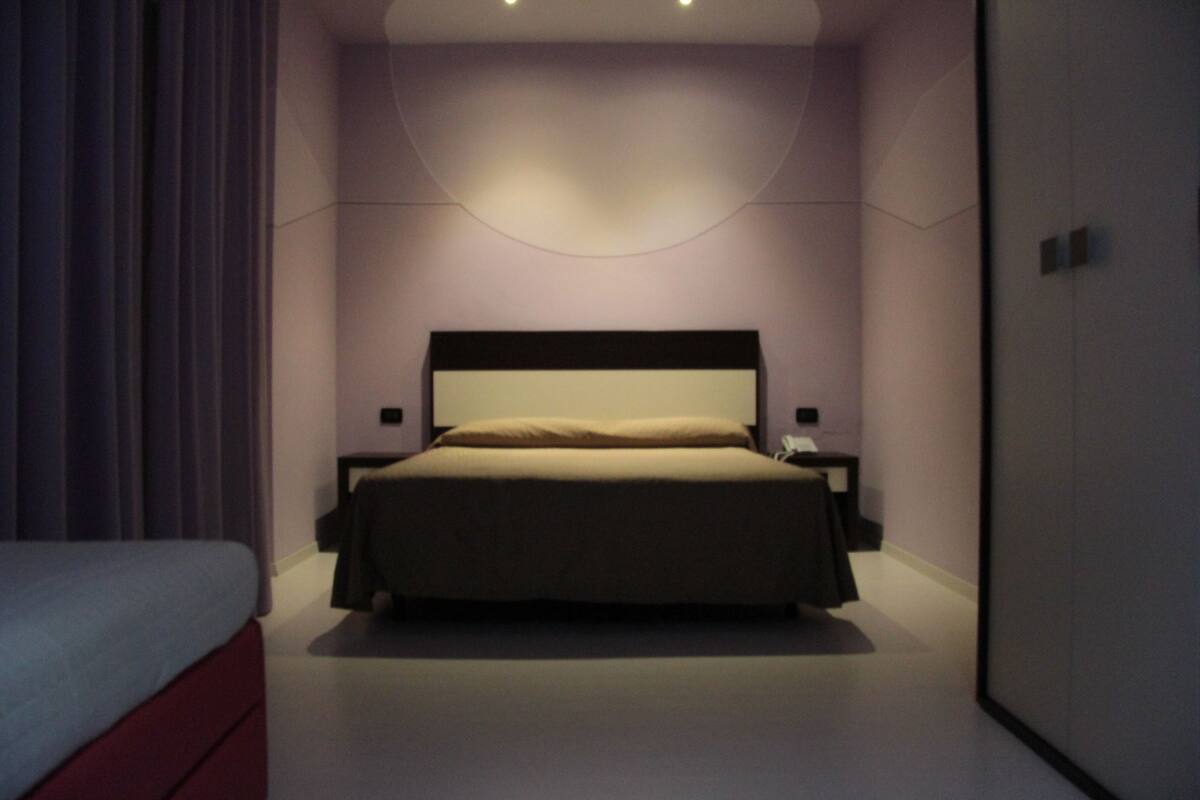 Una camera da letto moderna con un letto grande, comodini e un armadio.