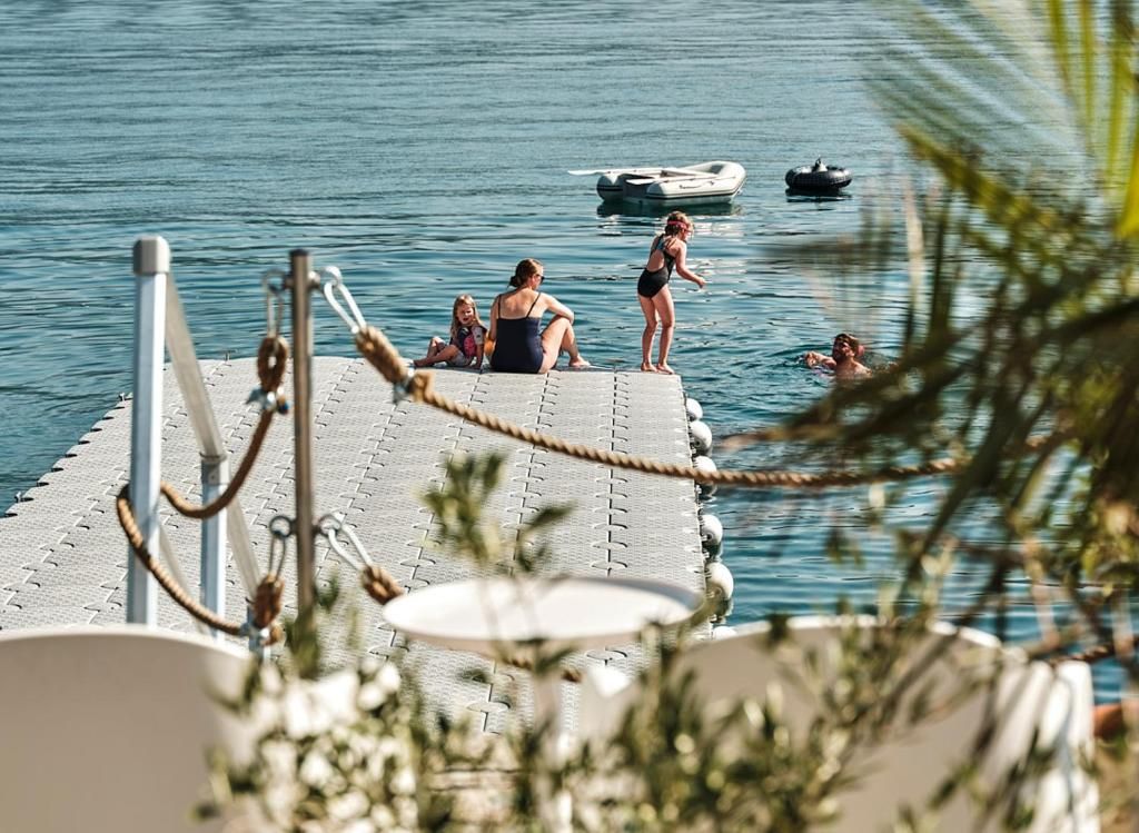 Eine Anlegestelle mit Personen, einem Boot und einer Seilbarriere.
